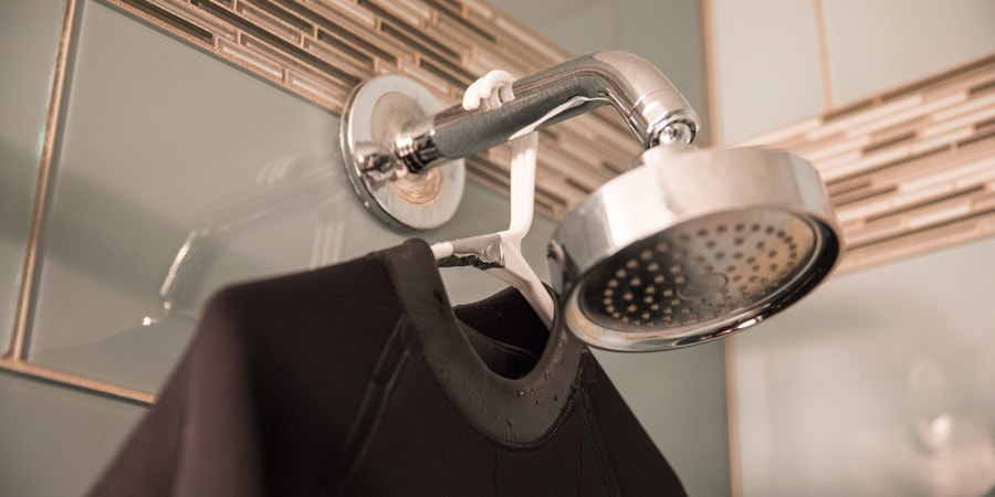 A wetsuit hanging on thick hangers to dry