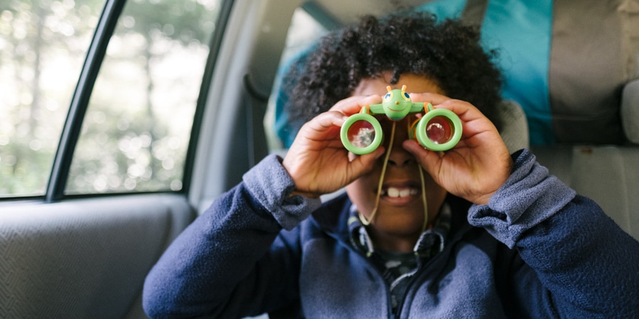 a kid with children's binoculars held up to their eyes