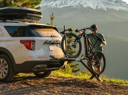 man mounting an e bike to a car rack via a ramp